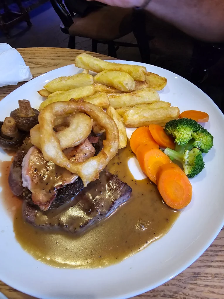 The pub lit up at night with hanging baskets